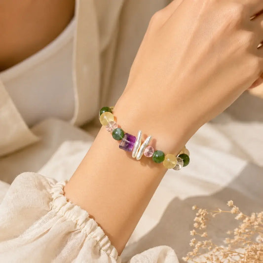 Woman wearing a natural green fluorite crystal bracelet with amethyst and rose quartz beads
